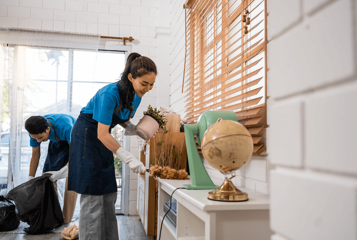 man and woman cleaning and dusting a room